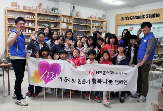 NS홈쇼핑 직원들이 사랑의 공부방 만들기 행복 나눔 캠페인에 참석해 어린이들과 기념촬영을 하고 있다. NS홈쇼핑 제공